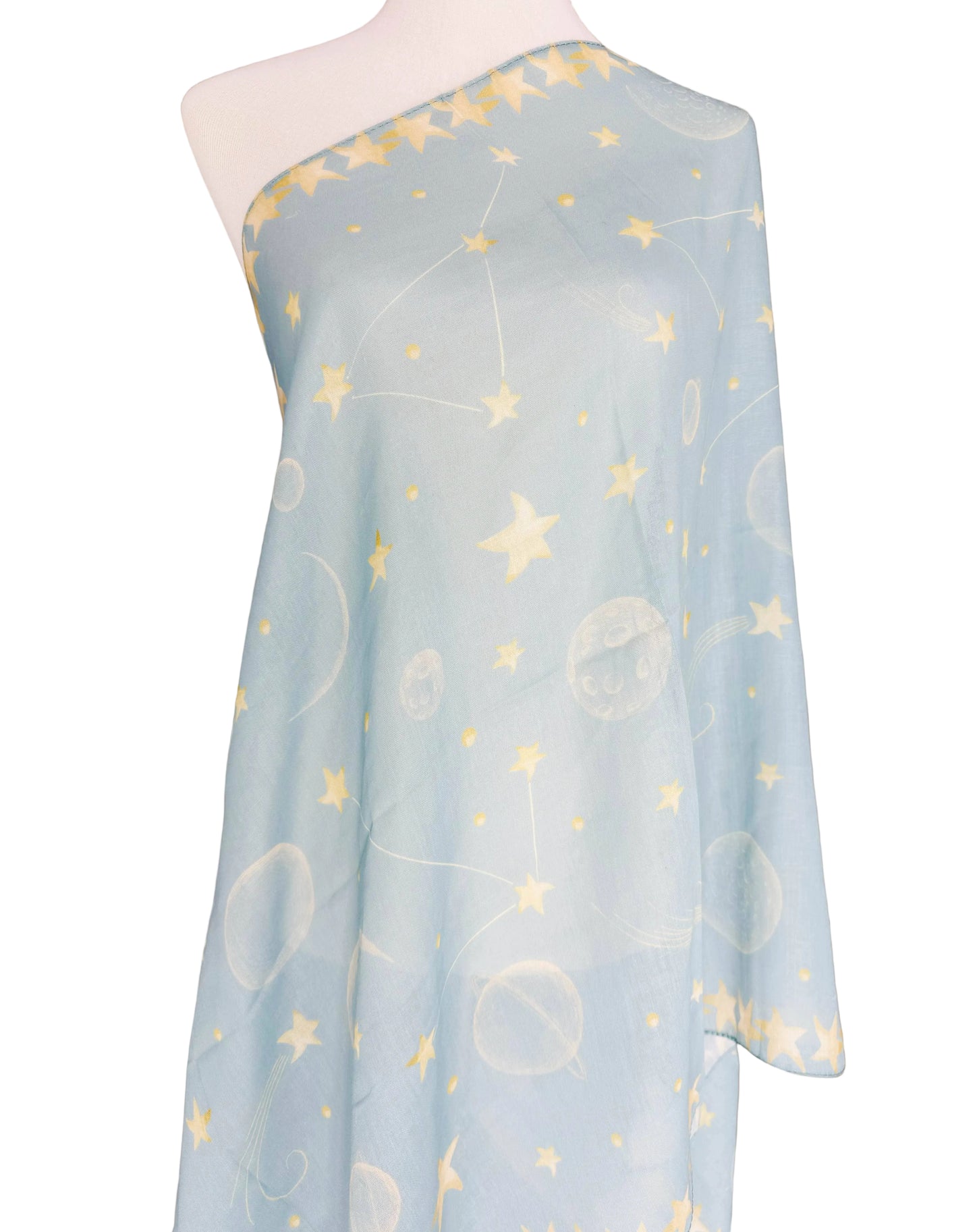 Light blue fabric with star and moon pattern on a mannequin against a brown background