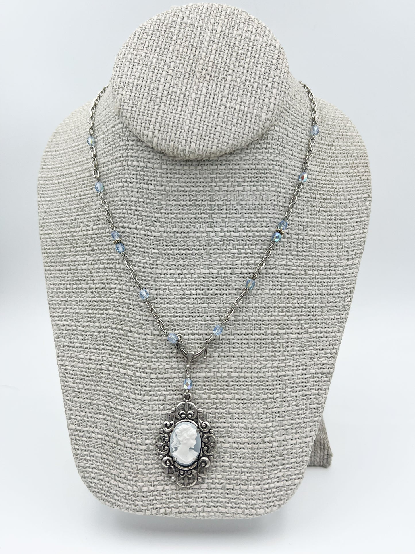 Necklace with a pendant on a gray bust against a white background