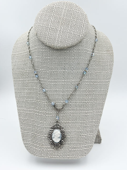 Necklace with a pendant on a gray bust against a white background