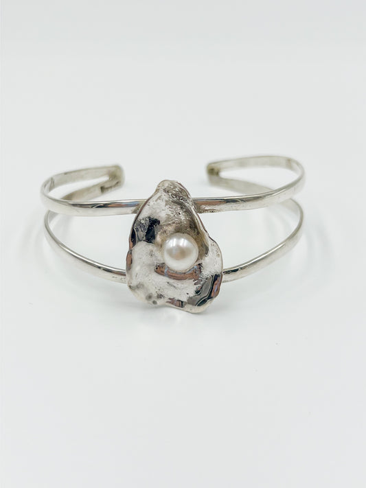 Indulge in luxury with our breathtaking Oyster Bracelet in .925 sterling silver, featuring a lustrous freshwater pearl at the center. As seen on TikTok, this must-have accessory.