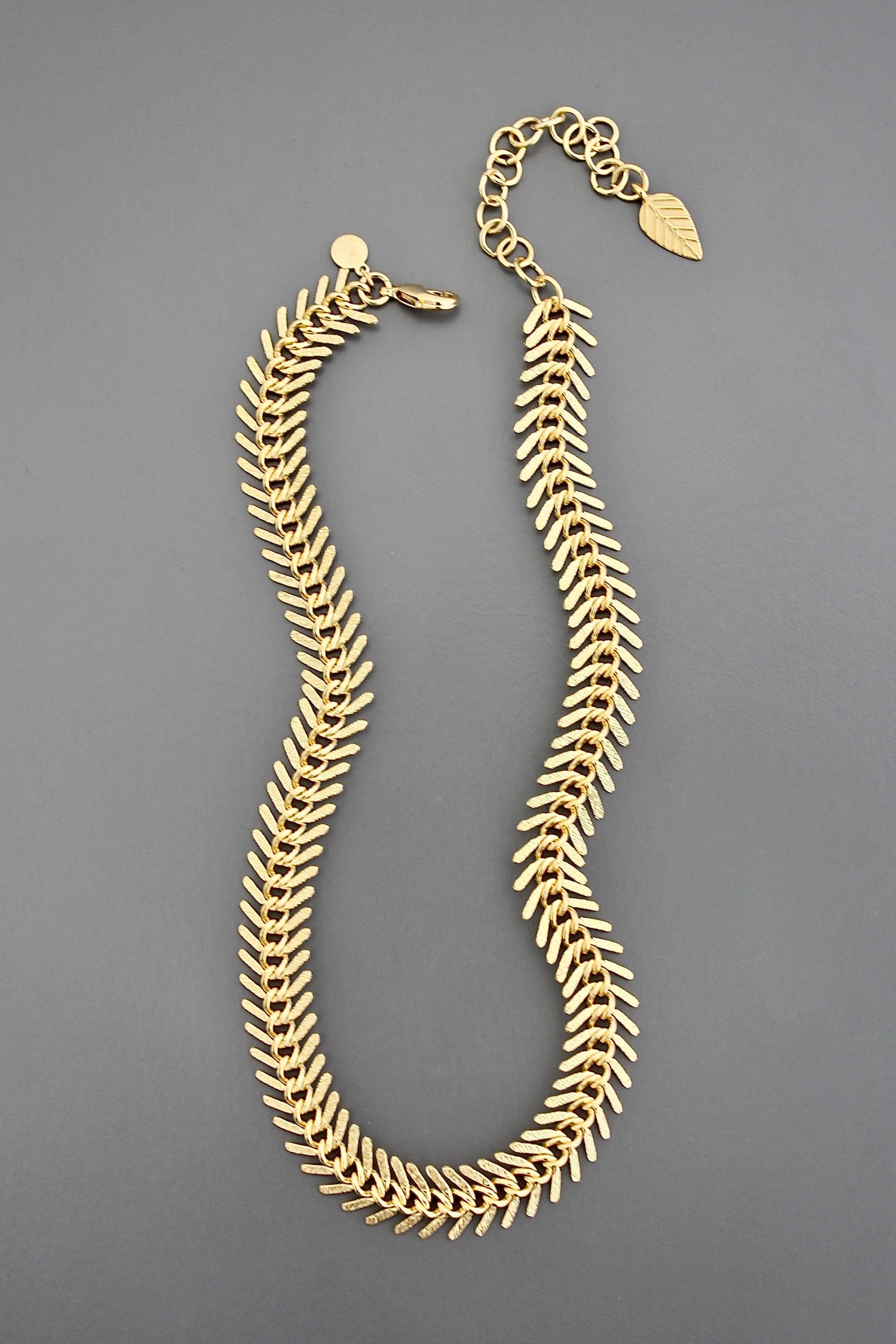 Gold necklace on a gray background