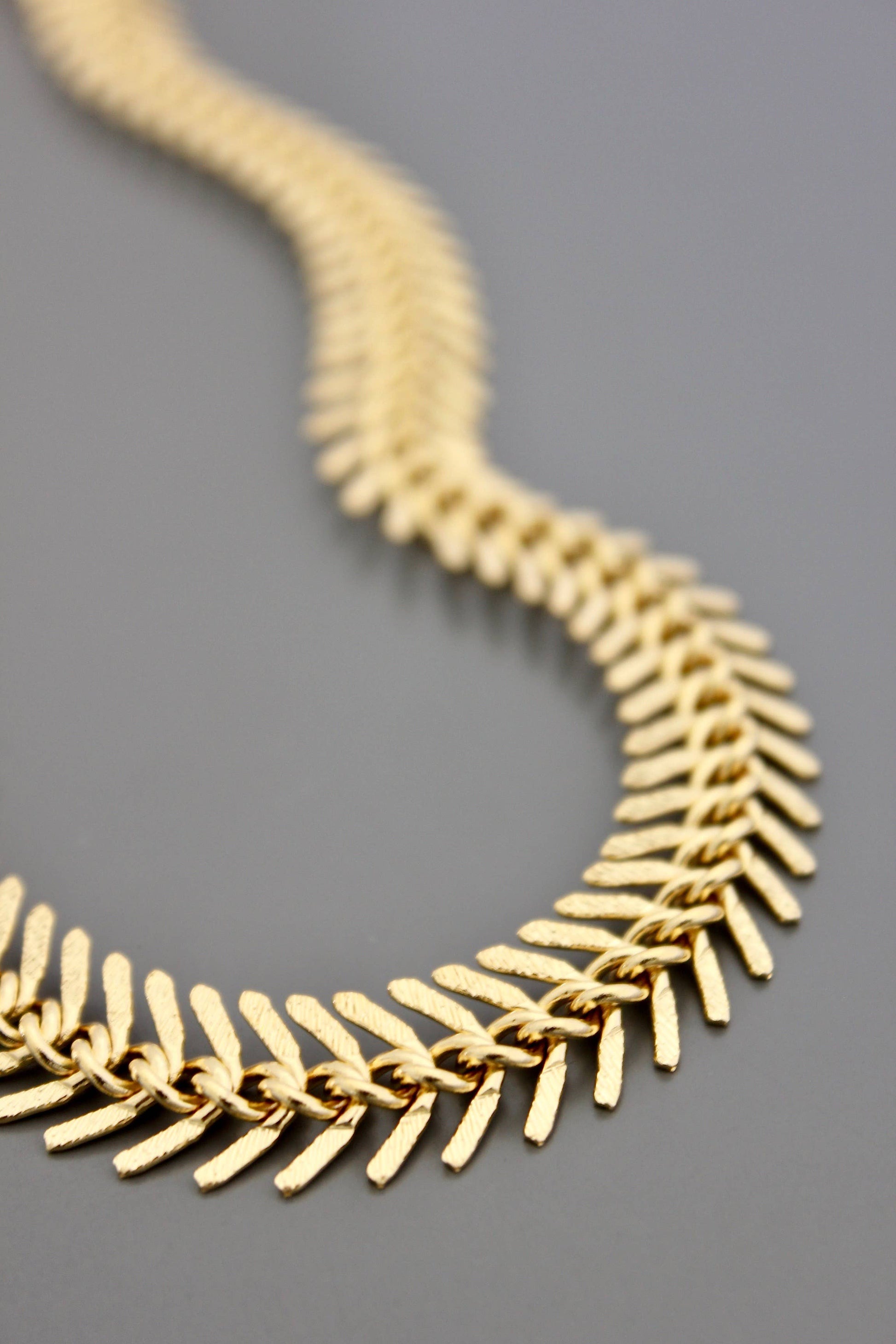 Gold necklace on a gray background