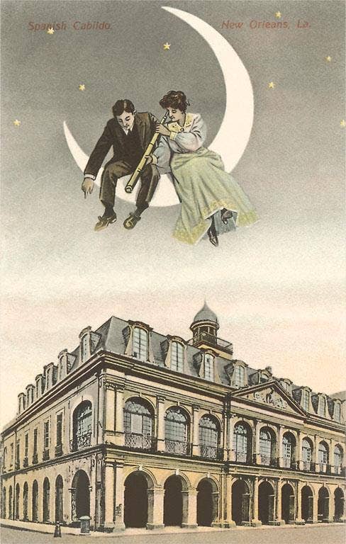 Couple sitting on a crescent moon above a building in New Orleans, Louisiana.