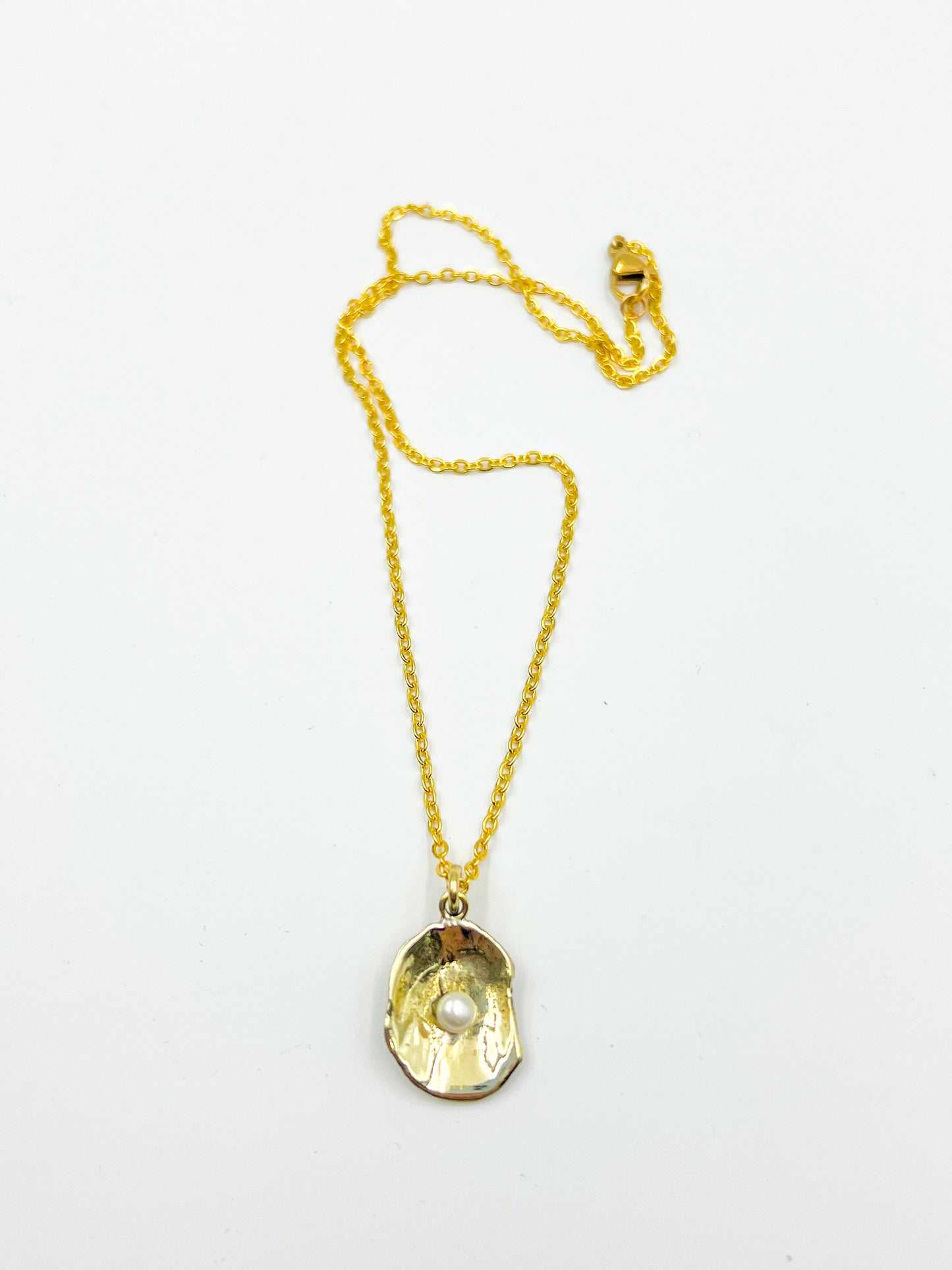 Gold necklace with a unique pendant on a white background