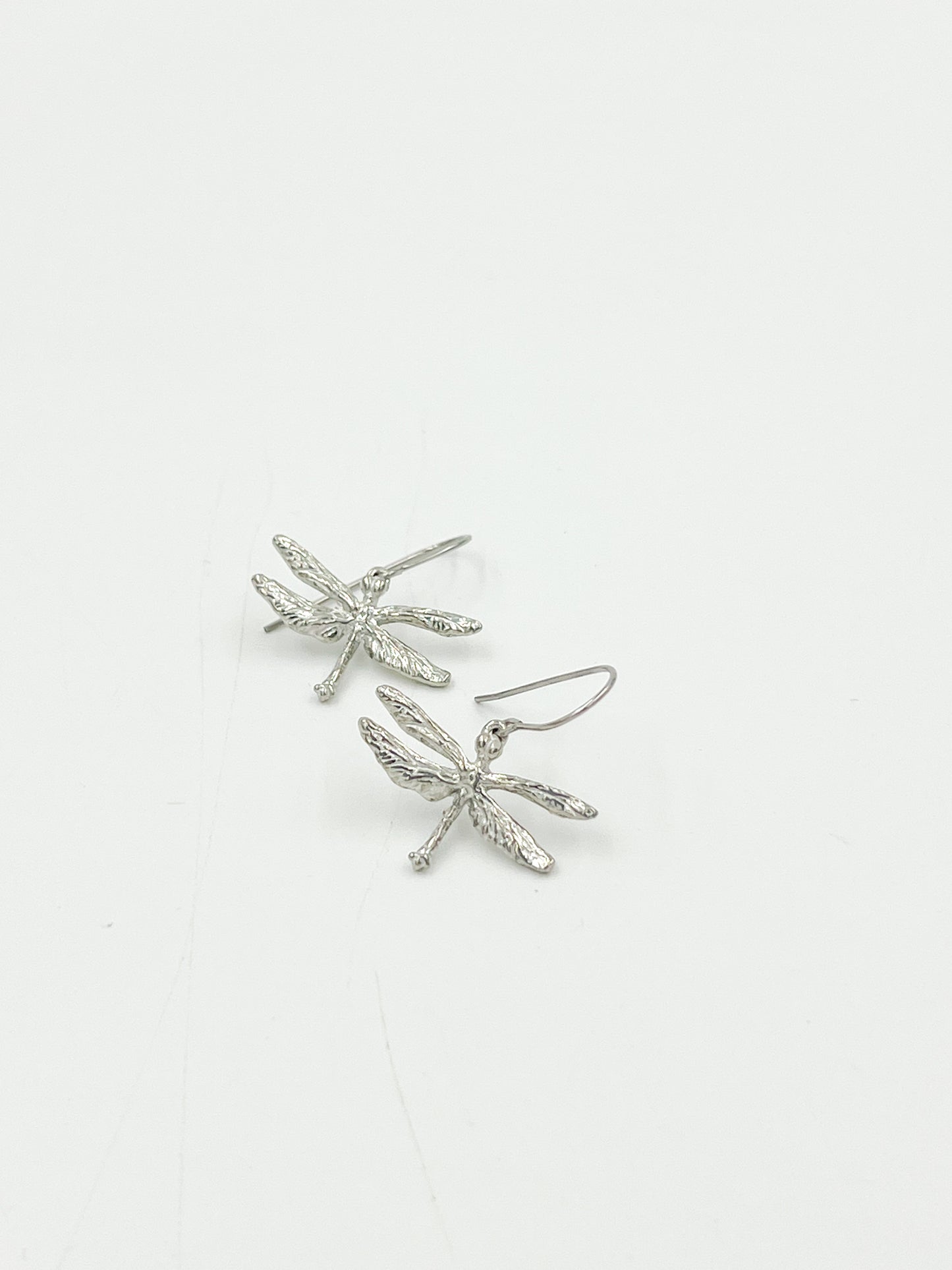 These aren't just any old earrings - they're Dragonfly Tiny Earrings, handcrafted with love by Maurice Milleur Designs and made from highly polished pewter findings and surgical steel wire. Measuring at 0.25″L and weighing only 1 gram, they're perfect for adding a touch of whimsy to any outfit. Made in the USA, of course.