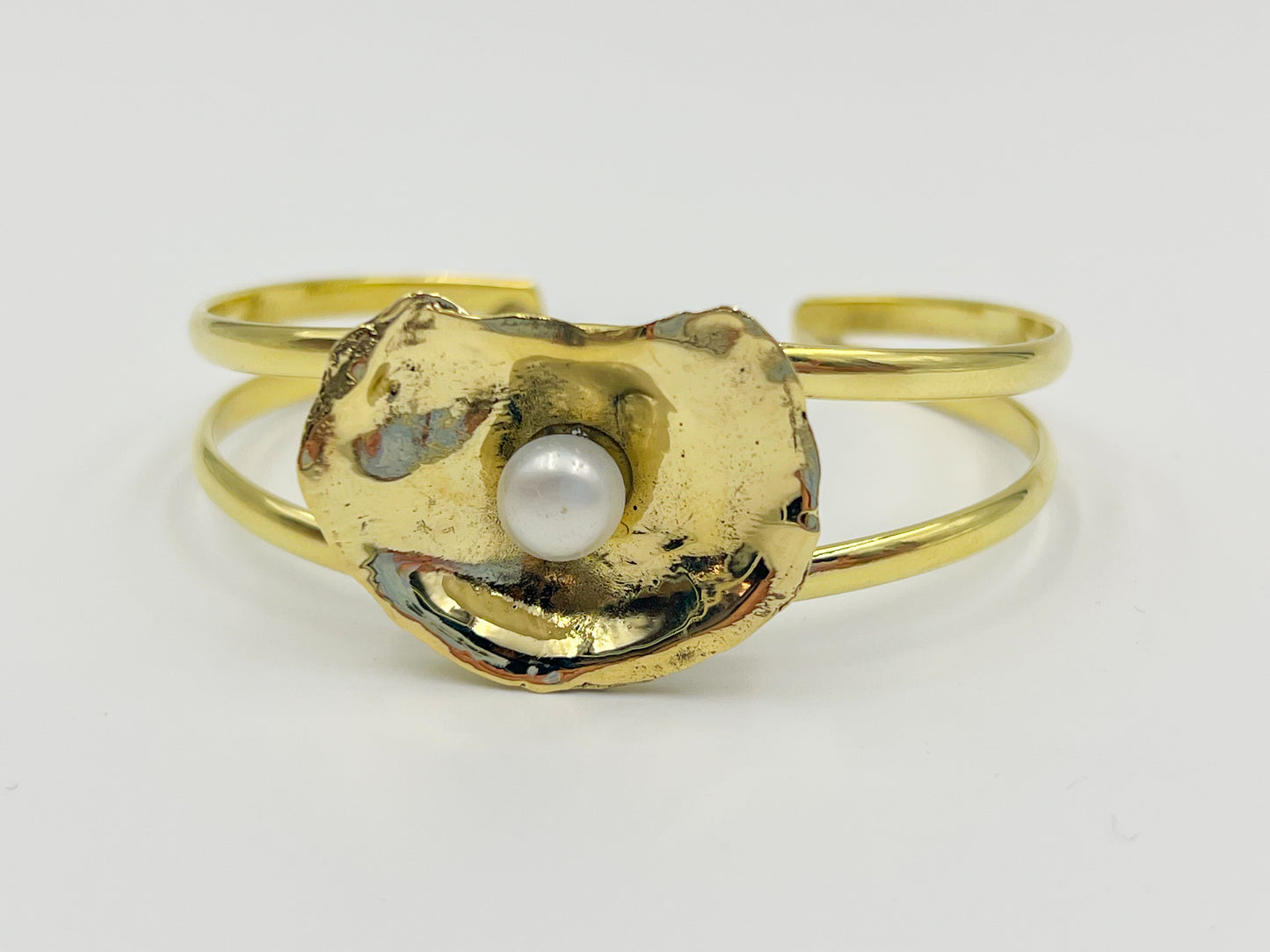 gold oyster bracelet with a white background