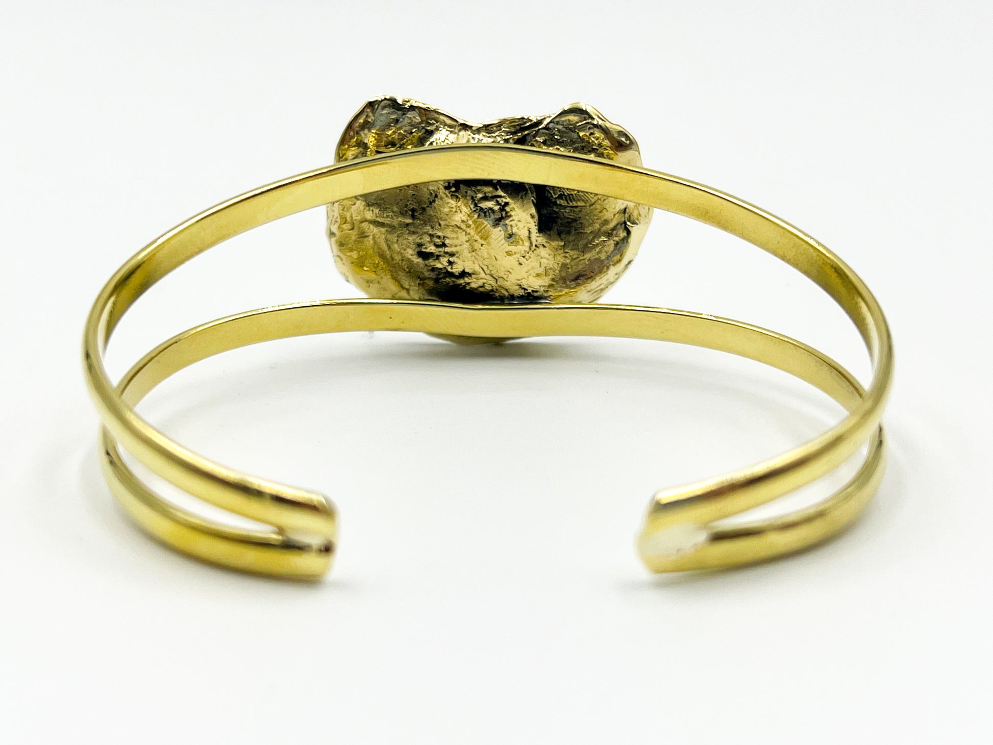Gold bracelet with a textured gold oyster on a white background